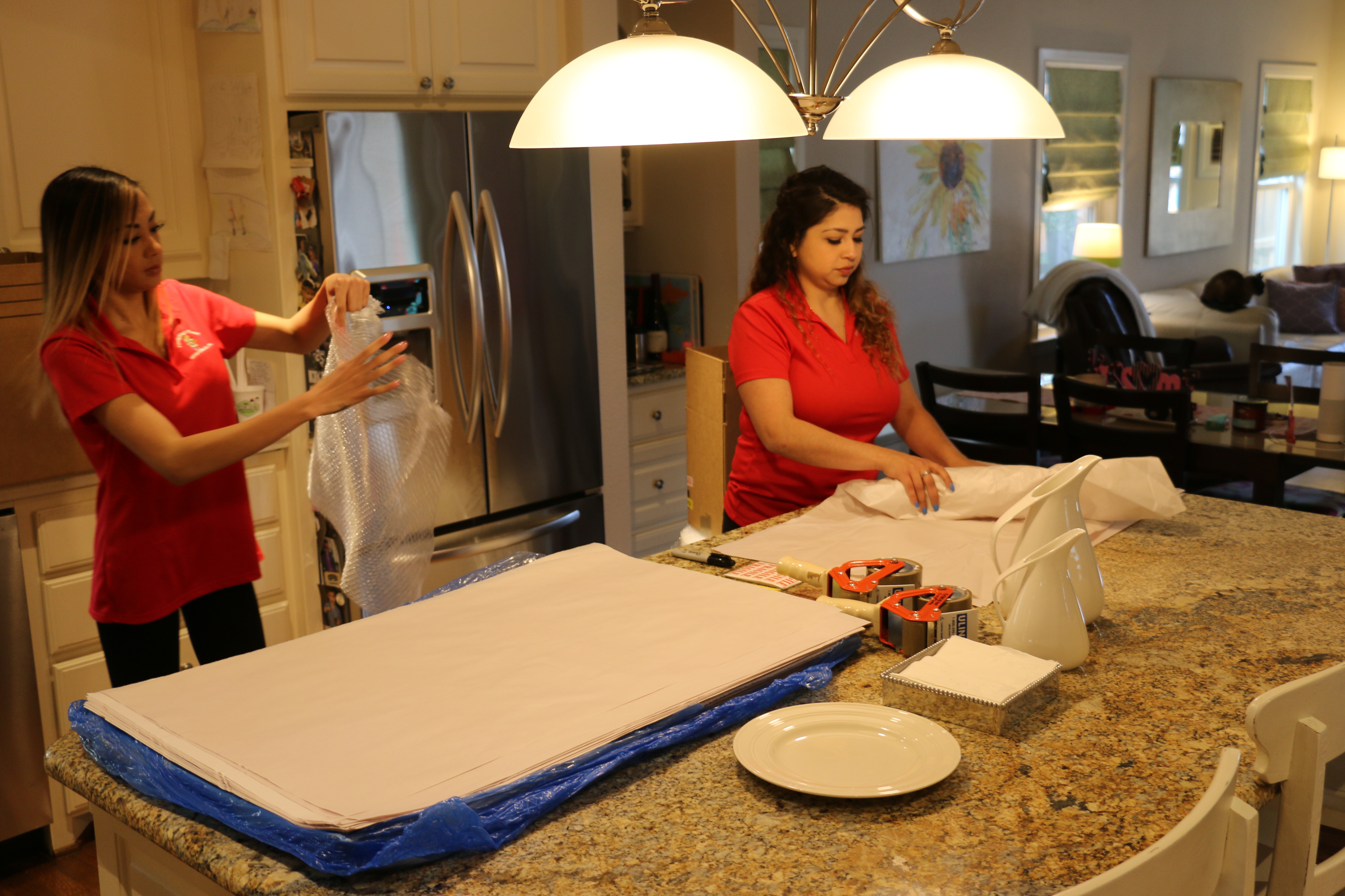 Professional Packing Services in TX - Two FF Lady Movers pack kitchen items in a house