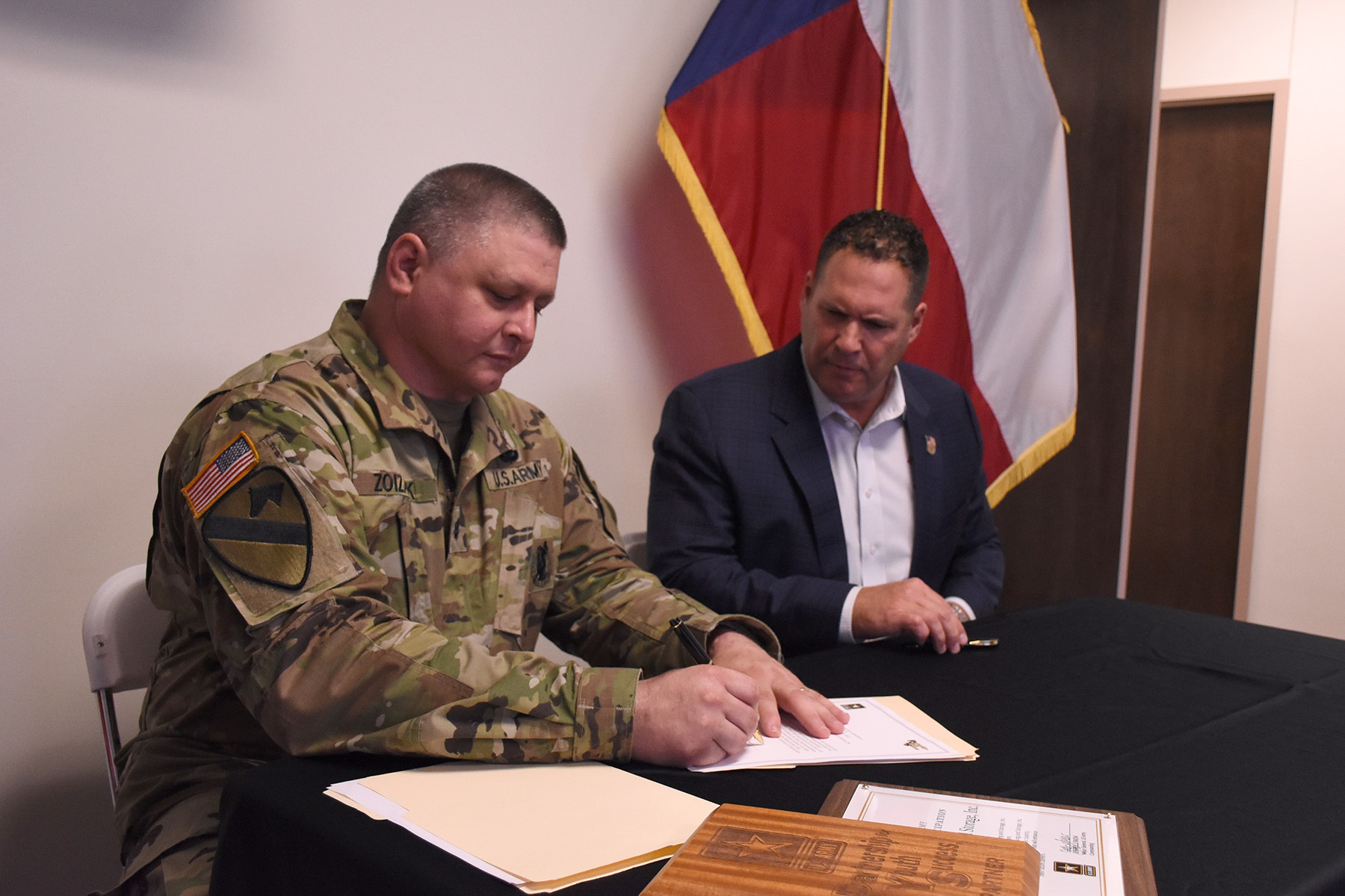 army soldier in fatigues signing document