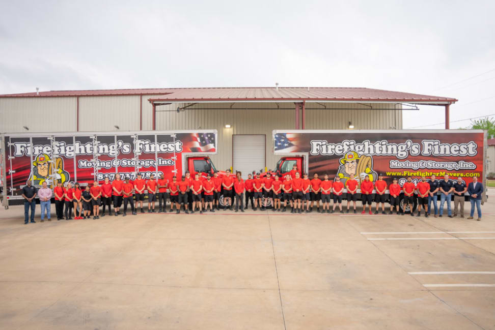 A team of professional movers standing in front of  moving trucks in Fort Worth, TX