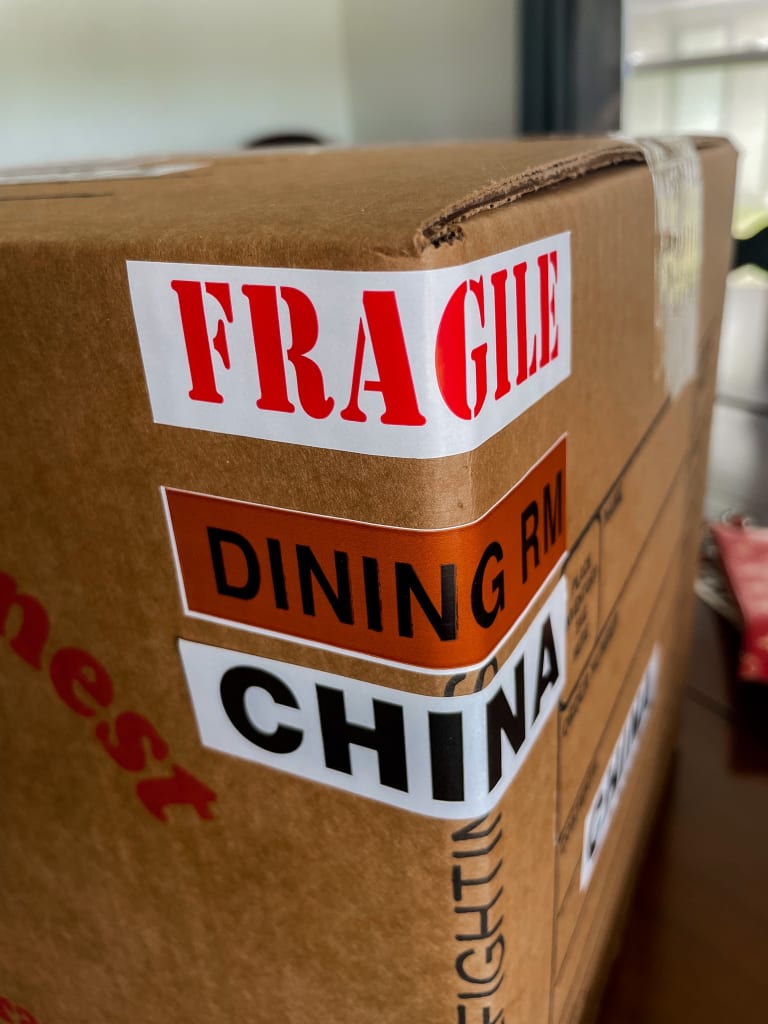 Close-up of a cardboard box labeled Fragile and China located in Dallas, TX